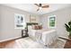 A neutral main bedroom features a ceiling fan, two windows, and a plush queen bed on a patterned rug at 1675 White Oak Way, Decatur, GA 30032