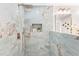 Modern walk-in shower with marble-look tiles, gold fixtures, and a built-in niche, offering spa-like luxury at 1675 White Oak Way, Decatur, GA 30032