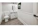 Well-lit bathroom with white vanity, decorative mirror, and wainscoting at 6486 Aquila Dr, Morrow, GA 30260
