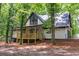 Exterior of the house showcasing the front facade, white siding, and inviting wooden porch at 6486 Aquila Dr, Morrow, GA 30260