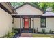 View of the front door with black trim and a vibrant red door at 6486 Aquila Dr, Morrow, GA 30260
