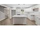 Well-lit kitchen with white cabinets, an island with a marble countertop, and modern pendant lighting at 6486 Aquila Dr, Morrow, GA 30260