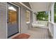 Inviting front porch with gray brickwork, white railing, a comfortable swing, and decorative patterned floor tile at 814 S Mcdonough St, Decatur, GA 30030