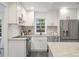 The remodeled kitchen offers stainless appliances, white cabinets, and a tiled backsplash at 814 S Mcdonough St, Decatur, GA 30030