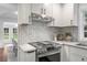 Updated kitchen showcasing gas range, white cabinets and a tiled backsplash at 814 S Mcdonough St, Decatur, GA 30030