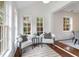 Bright sitting area with large windows, comfortable seating, and connecting doorway to the dining room at 814 S Mcdonough St, Decatur, GA 30030