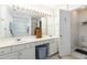 A bathroom with double sinks, a large mirror, and white cabinets at 11885 Carriage Park Ln, Duluth, GA 30097