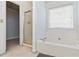 A bathroom with a soaking tub, shower with glass door, and a window at 11885 Carriage Park Ln, Duluth, GA 30097