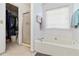 A bathroom with a soaking tub, shower with glass door, and a closet at 11885 Carriage Park Ln, Duluth, GA 30097