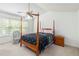 A bedroom features a four-poster bed, a ceiling fan, and a side table at 11885 Carriage Park Ln, Duluth, GA 30097
