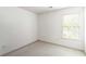 An empty bedroom with a window and off-white walls and carpet at 11885 Carriage Park Ln, Duluth, GA 30097