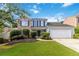 Charming two-story home with a manicured lawn, two-car garage and a mix of brick and siding at 11885 Carriage Park Ln, Duluth, GA 30097
