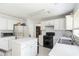 Spacious kitchen with white cabinetry, black appliances, and an island at 11885 Carriage Park Ln, Duluth, GA 30097