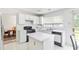 Functional kitchen featuring white cabinets and black appliances, with an island for extra counter space at 11885 Carriage Park Ln, Duluth, GA 30097