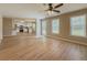 Bright living room featuring hardwood floors, a ceiling fan, and a view into the modern kitchen at 1904 Watercrest Cir, Lawrenceville, GA 30043