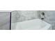 Close-up of luxurious soaking tub in main bath with marble style tile and chrome fixtures at 1904 Watercrest Cir, Lawrenceville, GA 30043