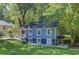 Charming blue two-story home with white trim and a covered porch surrounded by lush greenery at 1914 North Nw Ave, Atlanta, GA 30318