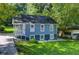 A charming blue house with a porch, surrounded by green trees and a well-maintained lawn at 1914 North Nw Ave, Atlanta, GA 30318