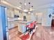 Modern kitchen with island, granite counters, stainless appliances, seating, and hardwood floors at 245 Fenwick Cir, Mcdonough, GA 30253