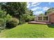 Green backyard with a brick patio, enclosed sunroom, and mature trees at 2826 Summit Ridge Dr, Marietta, GA 30066