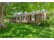 Charming brick home featuring a well-manicured lawn surrounded by mature trees and foliage at 2826 Summit Ridge Dr, Marietta, GA 30066