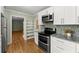 Well-lit kitchen featuring white cabinetry, mosaic backsplash, and modern stainless-steel appliances at 2826 Summit Ridge Dr, Marietta, GA 30066