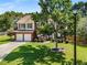 Well-maintained two-story home featuring a brick facade, mature tree, and attached two-car garage at 2740 Greymont Ct, Cumming, GA 30041