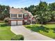 Charming two-story home with a well-maintained lawn and long driveway leading to a two-car garage at 2740 Greymont Ct, Cumming, GA 30041