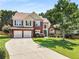 Charming two-story home with a well-manicured lawn, complemented by a two-car garage and inviting brick facade at 2740 Greymont Ct, Cumming, GA 30041
