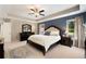 Large primary bedroom with tray ceilings, dark wood furniture, and access to the primary bathroom at 2740 Greymont Ct, Cumming, GA 30041