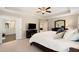 Large main bedroom with ceiling fan, tray ceilings, dresser, TV, and attached primary bathroom at 2740 Greymont Ct, Cumming, GA 30041