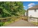 Wooden back deck with a wooden railing overlooks a green backyard with foliage and a blue sky at 275 Springs Xing, Canton, GA 30114
