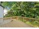 Wooden back deck with a wooden railing overlooks a lush green backyard with trees at 275 Springs Xing, Canton, GA 30114