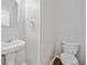 Powder room featuring a pedestal sink, round mirror, and a modern toilet at 275 Springs Xing, Canton, GA 30114