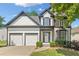 Charming two-story home showcasing a two-car garage, lush landscaping, and a mix of siding and stone finishes at 275 Springs Xing, Canton, GA 30114
