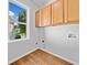 Bright laundry room with hardwood floors, upper cabinets, and a large window at 275 Springs Xing, Canton, GA 30114