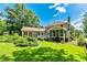 Spacious backyard featuring a well-maintained lawn, mature trees, and a charming screened-in porch at 115 Edgewater Way, Peachtree City, GA 30269