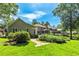 Sprawling backyard with manicured lawn, lush landscaping, mature trees and a covered patio for outdoor enjoyment at 115 Edgewater Way, Peachtree City, GA 30269