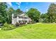 Beautiful two-story home with a lush green lawn and mature trees on a sunny day at 115 Edgewater Way, Peachtree City, GA 30269