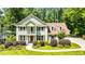 Charming two-story home featuring a well-manicured lawn, brick facade, and inviting front porch at 115 Edgewater Way, Peachtree City, GA 30269