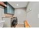 Well-equipped laundry room with modern washer and dryer, storage cabinets, butcher block top and utility sink at 115 Edgewater Way, Peachtree City, GA 30269