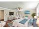 Staged main bedroom with beautiful hardwood floors and a seating area by a window at 115 Edgewater Way, Peachtree City, GA 30269