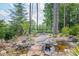 Landscaped backyard with winding gravel path, waterfall feature, and mature trees provides a peaceful setting at 2380 Tayside Nw Xing, Kennesaw, GA 30152