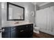 Well-lit bathroom features a granite countertop vanity, a decorative mirror, and a shower with white curtain at 2380 Tayside Nw Xing, Kennesaw, GA 30152