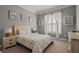 Cozy bedroom features neutral walls, light furnishings, decorative shelving, and a bright window at 2380 Tayside Nw Xing, Kennesaw, GA 30152