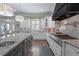 This kitchen features a center island, stainless steel appliances, tiled backsplash and opens to the sunroom at 2380 Tayside Nw Xing, Kennesaw, GA 30152