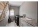 Well-lit laundry room featuring a washer and dryer, utility sink, storage cabinets, and window at 2380 Tayside Nw Xing, Kennesaw, GA 30152