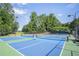 Outdoor pickleball courts with vibrant blue and green surfaces, surrounded by mature trees and offering a recreational amenity at 2380 Tayside Nw Xing, Kennesaw, GA 30152