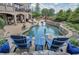 Backyard featuring a custom pool, lounge seating, and a stone patio, perfect for outdoor enjoyment at 2380 Tayside Nw Xing, Kennesaw, GA 30152