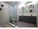 Bathroom featuring a glass shower and dual sink vanity with modern fixtures and lighting at 260 Lakemont Dr, Roswell, GA 30075